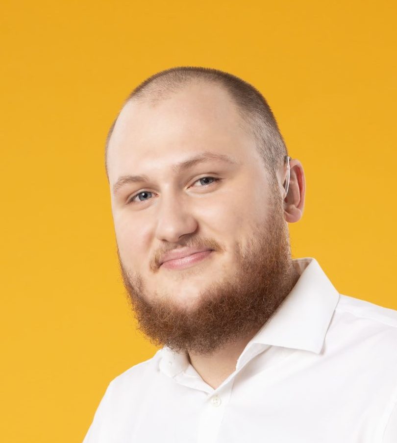 Zdjęcie przedstawia portret Jakuba Stanisławczyka w białej koszuli na żółtym tle.