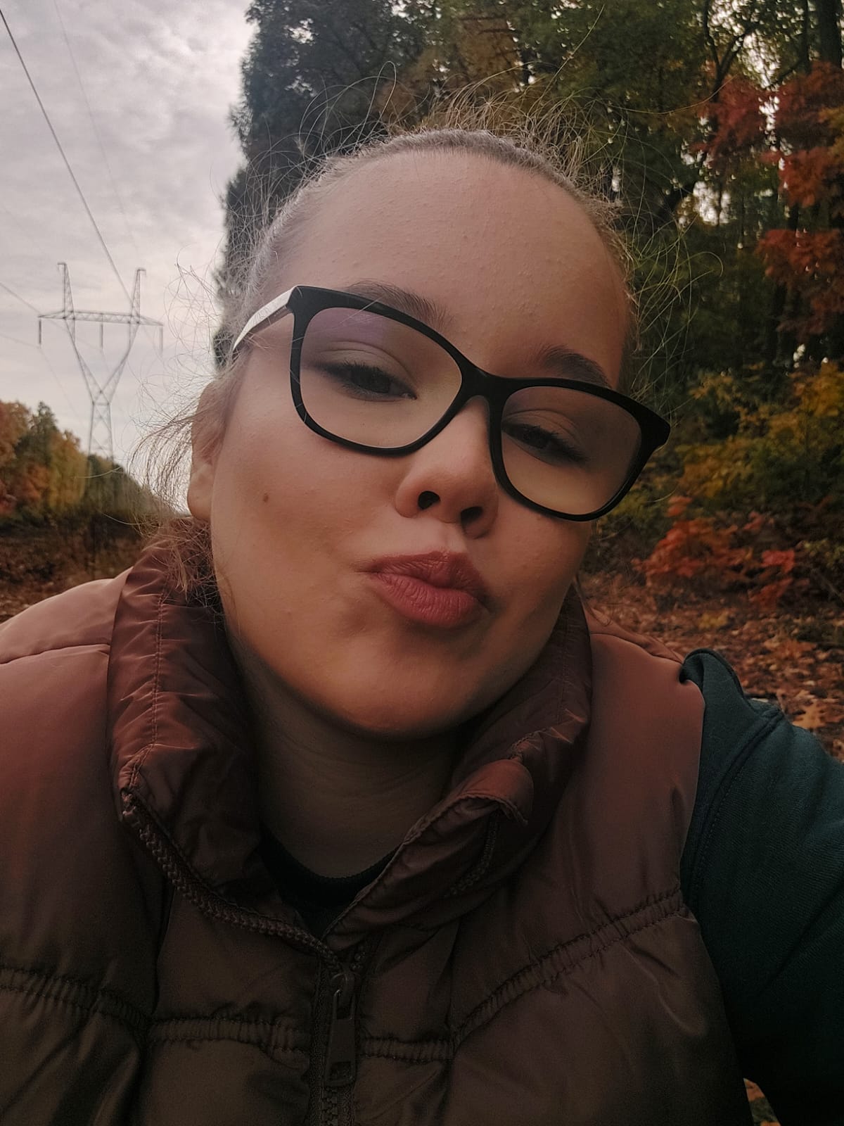 Selfie Zuzanny - kobiety koło dwudziestki, która pozuje do aparatu przesyłając "buziaczka".